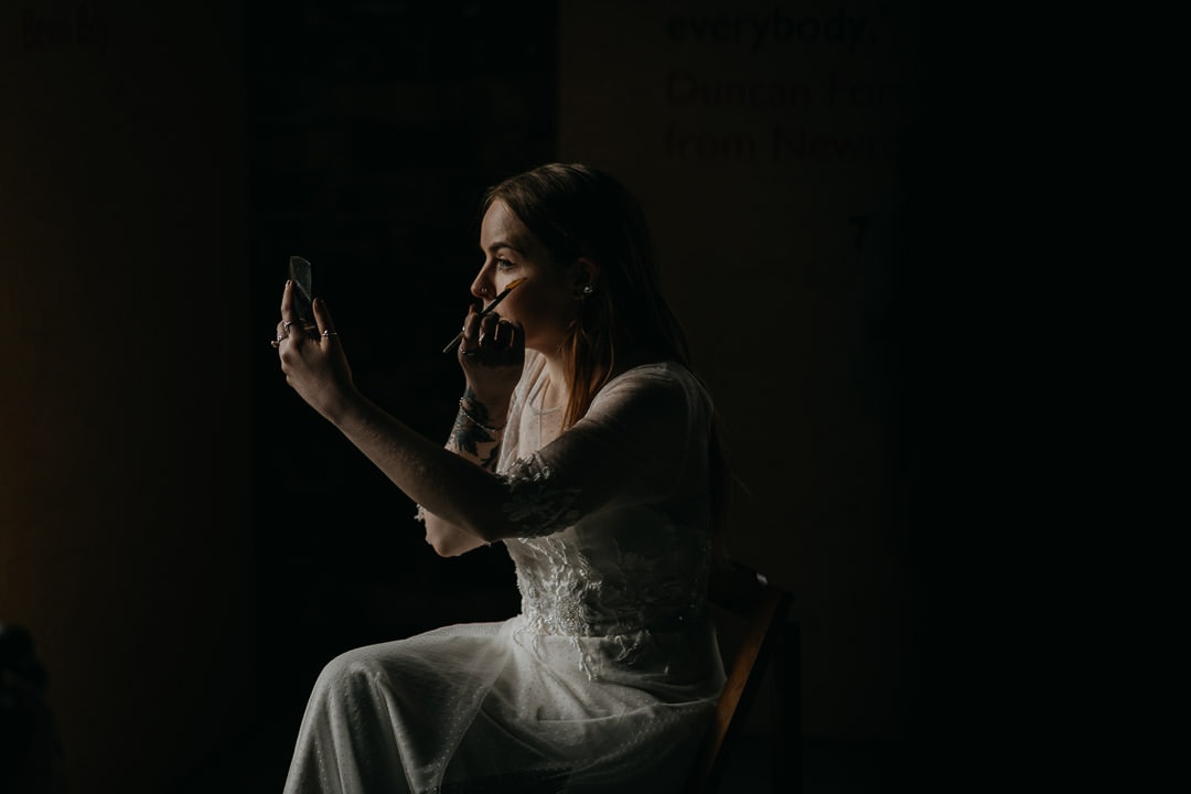 Bride putting on makeup before elopement ceremony in Scotland