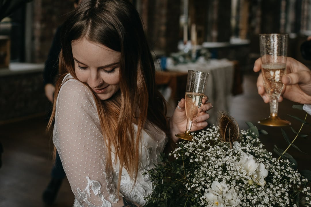Happy bride at the national mining museum, popping champagne - scottish elopement