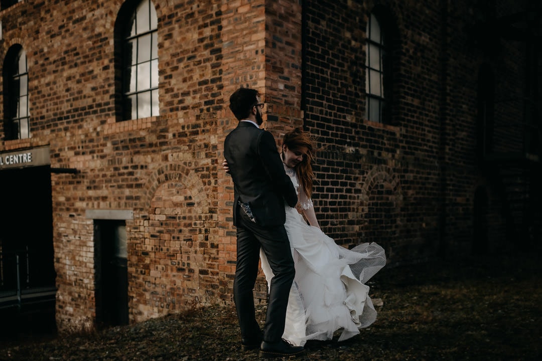 Couple with windy hair and dress outside the Newbattle Mining Museum - Scotland elopement photographer