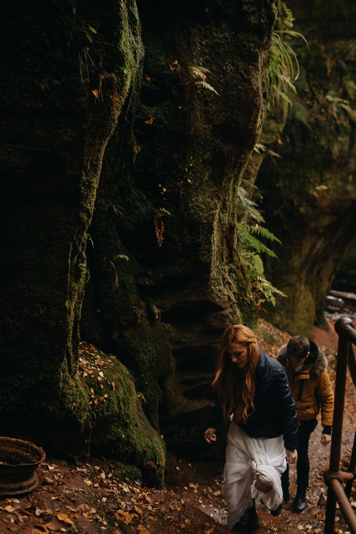 adventurous couple rock climbing in Devil's Pulpit elopement in Scotland