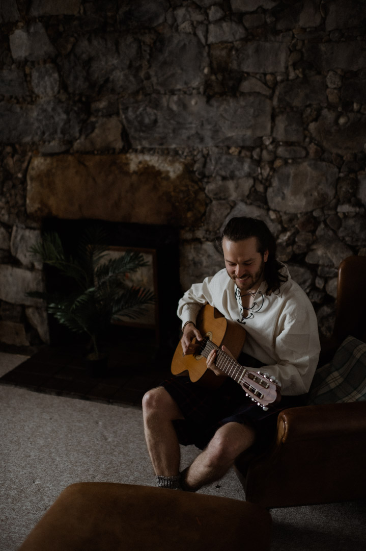 Isle of Mull groom playing guitar