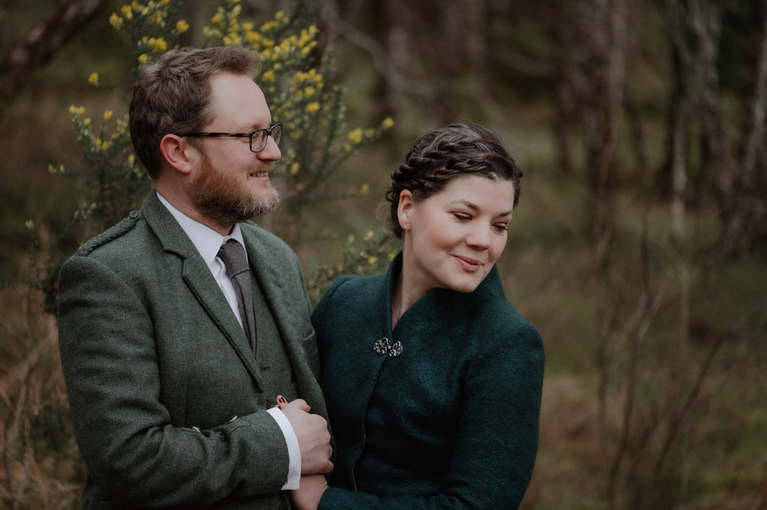 Outlander elopement couple by trees and loch in Scottish Highlands