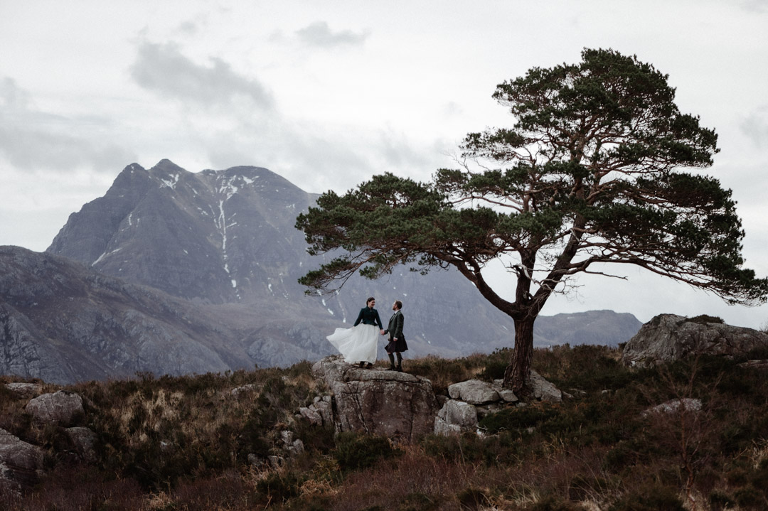 Winter elopement couple in Torridon by trees and mountains