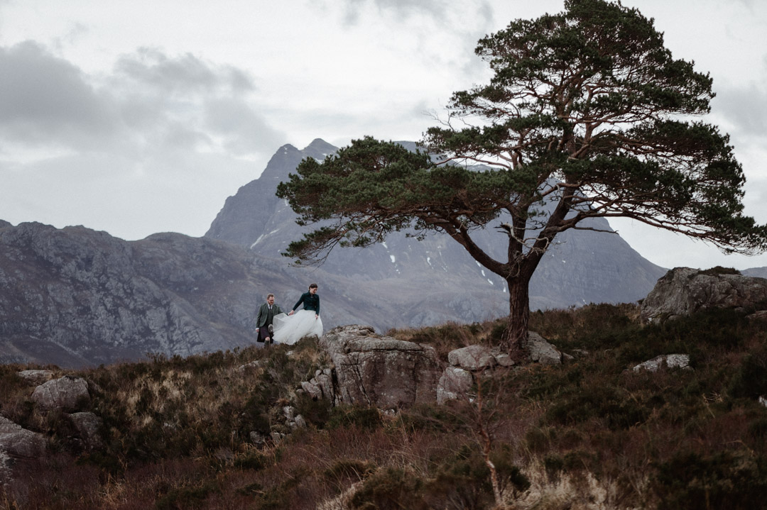 Winter elopement couple in Torridon by trees and mountains