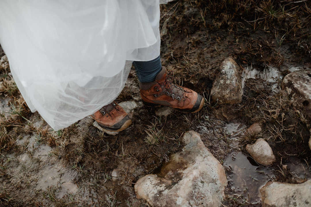 Boots trampling through the mud on winter elopement in Scotland