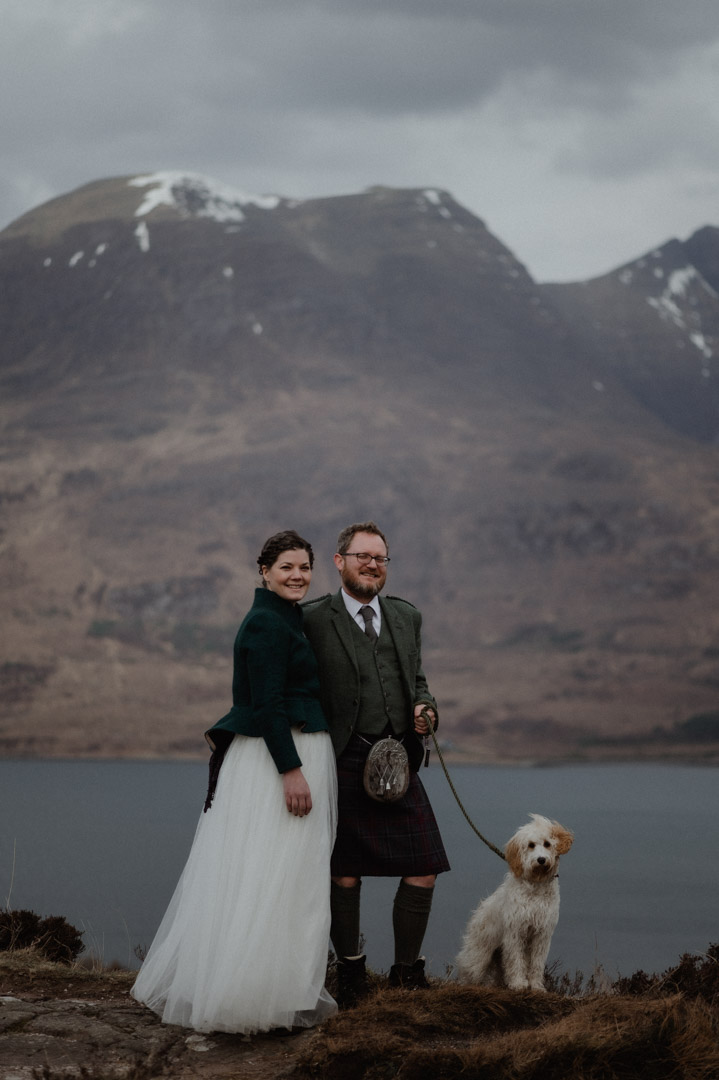 Winter elopement in Scottish hills with dog at a loch