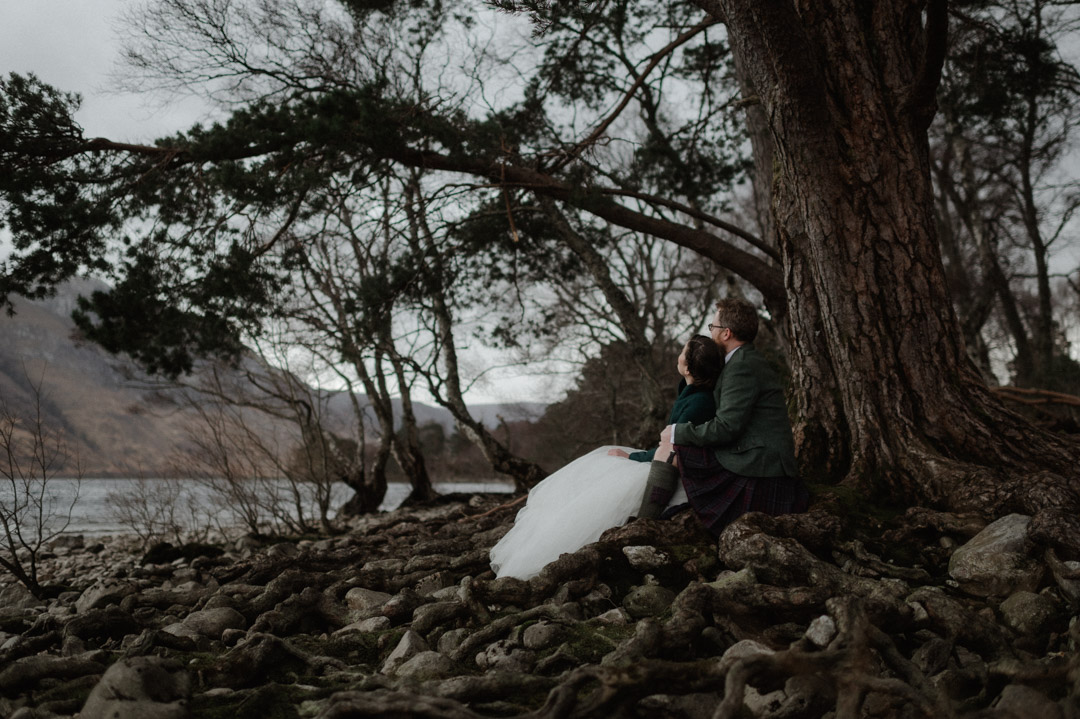 Outlander elopement couple sitting at a tree - eloping at a loch in Torridon