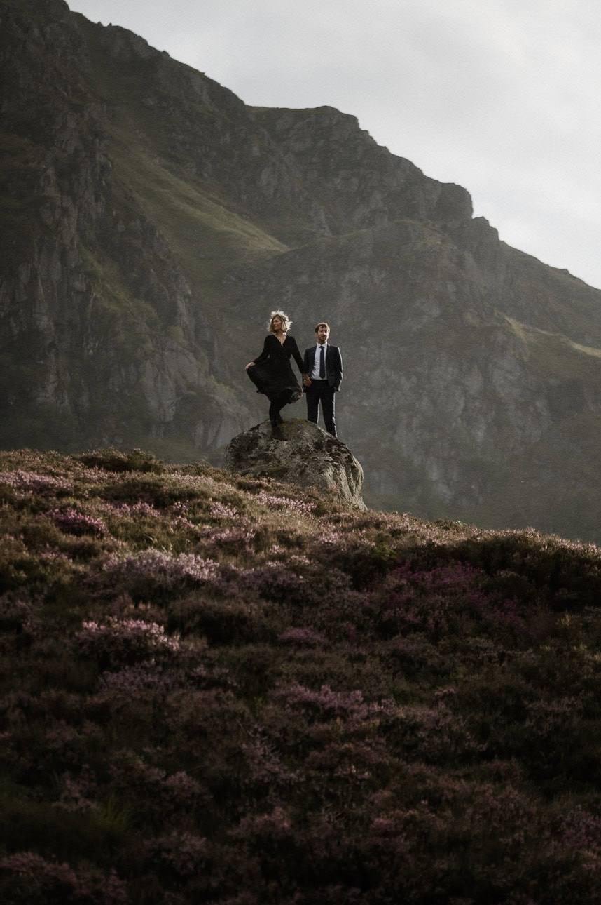 Couple standing on rock with ethereal cinematic light during Cairngorms mountain elopement