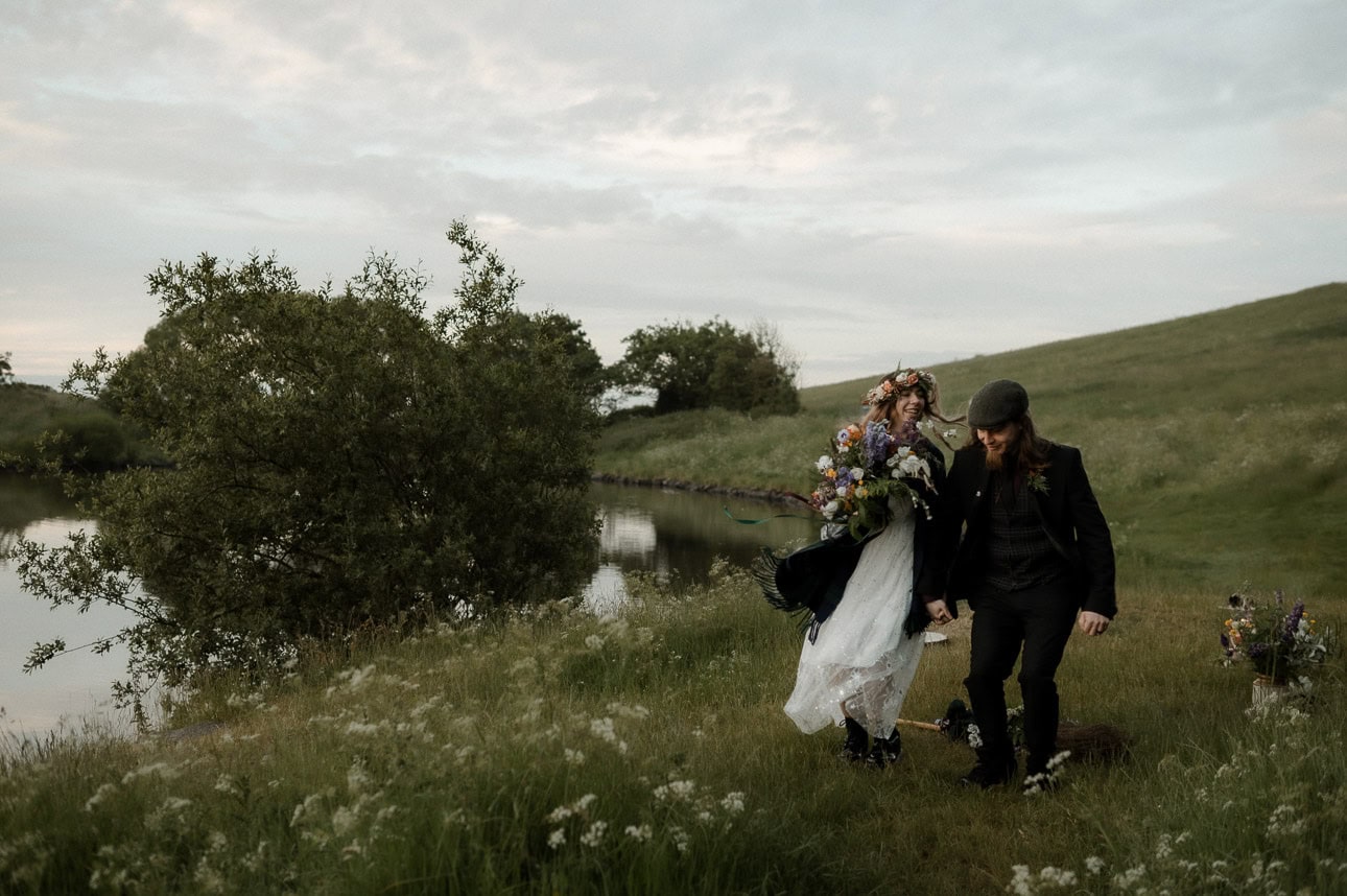 pagan solstice elopement in Edinburgh - couple jumping the broom / besom